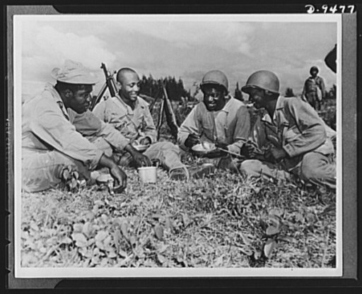 With an airfield security detachment in Hawaii. Constantly on maneuvers in Hawaii, members of an airfield security detachment enjoy chow in the field. Shown left to right are: Corporal John L. Sellers, Columbus, Georgia; Private Joseph English, Greensboro, Georgia; Private Bennie W. Samuel, Albany, 