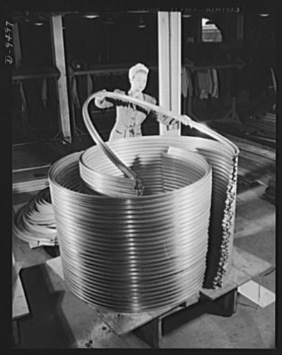 Production. BT-13A ("Valiant") basic trainers. A girl worker at Vultee's Downey, California plant stacking dural strips that will go into modern warplanes. At the Downey plant is made the BT-13A ("Valiant") basic trainer--a fast, sturdy ship powered by a Pratt and Whitney Wasp engine
