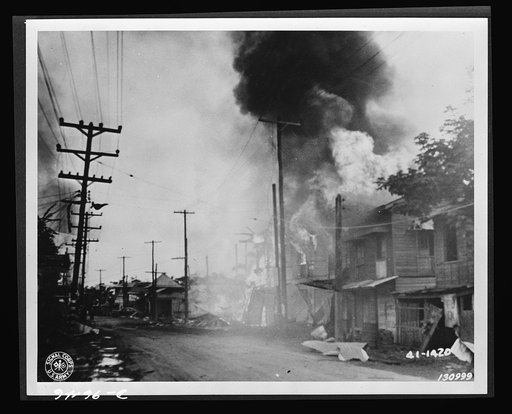 A burning building along Taft Avenue which was hit during the Japanese air raid in Barrio, Paranque, December 13, 1941, the Philippine Islands