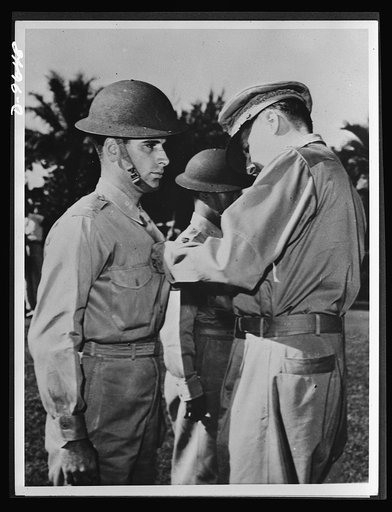 Manila, the Philippine Islands. For extraordinary heroism during attacks on Jap bridgeheads at Vigan, in Northern Luzon, Lieutenant Jack Dale of the U.S. Army Air Corps received a Distinguished Service Cross from General MacArthur (right) before Japanese forces forced American troop retirement from 