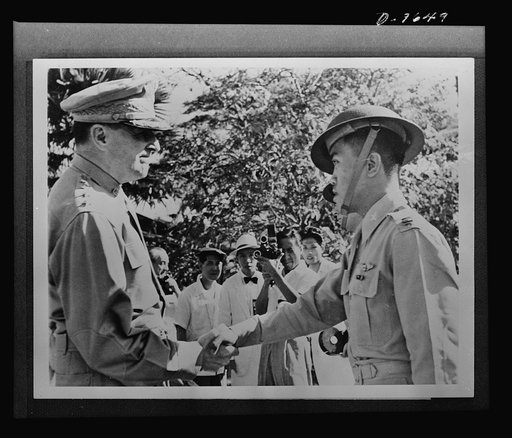 General Douglas MacArthur, left, congratulates Captain Villamor of the Philippine Air Force, after awarding him the Distinguished Service Cross, December 22, 1941. Captain Villamor was one of the small group of flyers that did heroic service in the Battle of Bataan