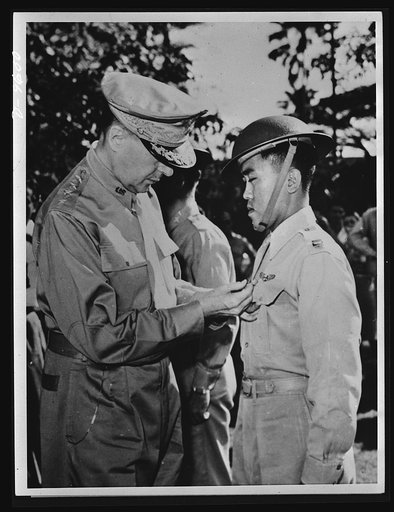 Manila, the Philippine Islands. In one of the last pictures to leave the Philippines before Manila fell to the Japs, General Douglas MacArthur (left) is shown pinning a Distinguished Service Cross on Captain Jesus A. Villamor, of the Philippine Air Force, for heroism in the air. In the center backgr