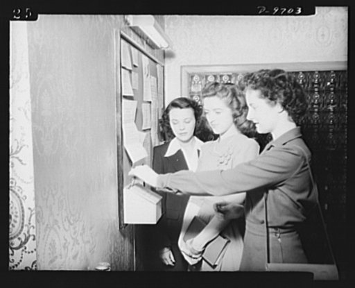 War workers. Social activities.  Three government girls at Scott's Hotel, Washington, D.C., a government hotel for women war workers, place their bids in the "date box" for a serviceman's dance