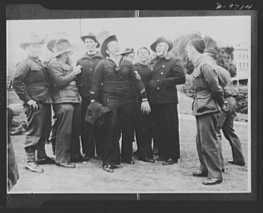 This time the soldier's hat gets the laughs! American sailors just landed in Australia exchange hats with Commonwealth soldiers--and find them as amusing as women's bonnets back home