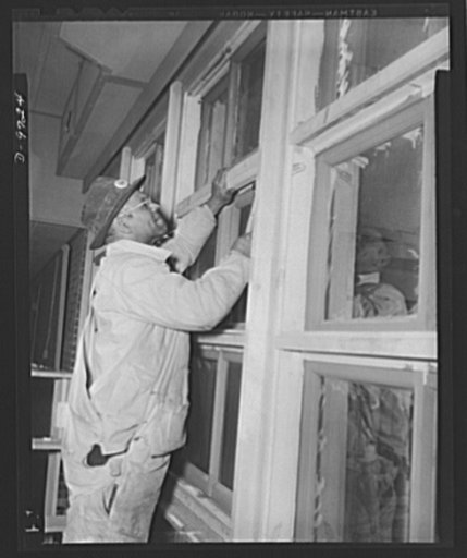 Latest addition to D.C. War Housing Program. One of 600 skilled workers employed in the construction of Wake and Midway Halls, now being completed by Samuel Plato, contractor, for 1,000 Negro women war workers in Washington, D.C. Photo shows carpenter fitting window