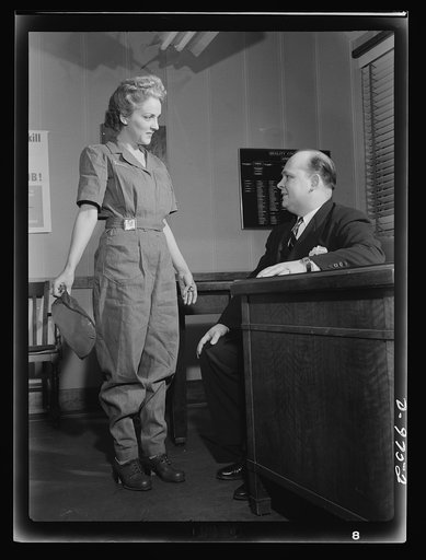 Safe clothes for women war workers. Correctly dressed, correctly coiffed and ready for work, Eunice Kimball shows her new safety uniform and hair-do to Bendix's chief inspector, Walter Rodgers, who thoroughly approves the transformation. In compliance with all safety rules, her uniform is also smart