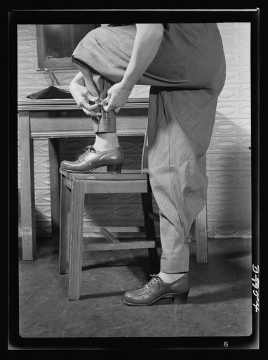 Safe clothes for women war workers. A closeup of Eunice's new uniform reveals one of its most important safety factors: the tight-buttoning trouser ankles which prelude the possibility of a loose trouser's catching in moving machinery. Note also the sturdily built, comfortable safety shoes, with box