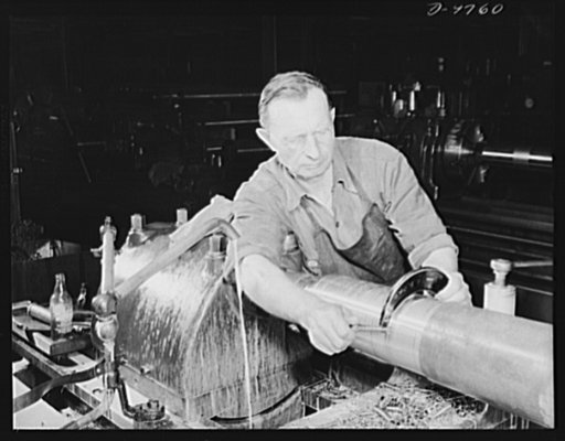 Production. 105 mm. howitzers. Adolph Pranewicz of Milwaukee, who has a son in the Marines, checking off rough material with a gauge after the first turning on a lathe of a 105 mm. howitzer at the plant of Chain Belt Company, Milwaukee, Wisconsin