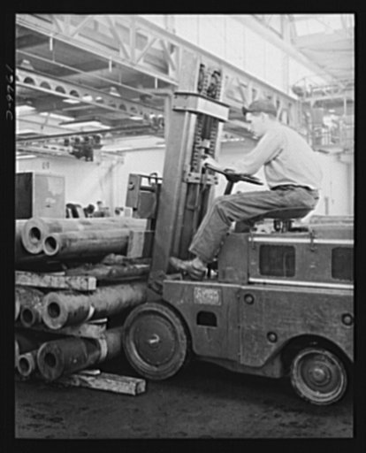 Production. 105 mm. howitzers. Richard Bluhn removing rough material as it comes from the steel mills to be turned into 105 mm. howitzers at the Milwaukee, Wisconsin plant of Chain Belt Company