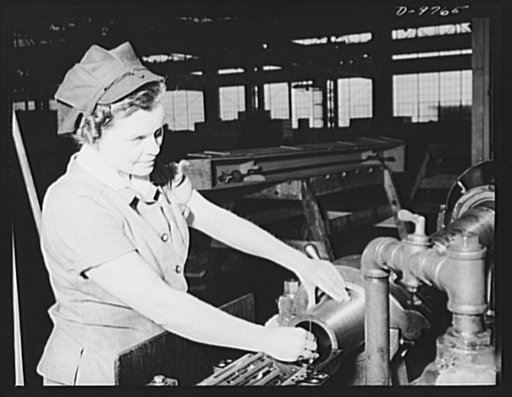 Production. 105 mm. howitzers. Lillian Goritschnig with two sons in the service, one overseas, and a husband ready to go into the service, inspecting the inside of a 105 mm. howitzer on a lathe at the Milwaukee, Wisconsin plant of Chain Belt Company, with microbrand and also shot-changing the honing