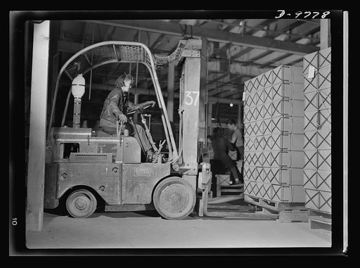 Women in essential services. Ethel Peterson, twenty-seven, an expert lift-truck operator at the Paraffine Company in Emeryville, California. Her job demands manual skill and excellent driving judgement, for sharp curves must be rounded and the cargo must be handled with precision and speed at all ti