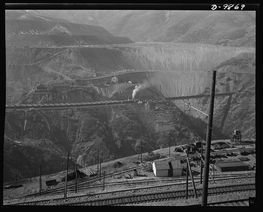Utah Copper: Bingham Mine. Part of the open-pit workings of the Utah Copper Company, at Bingham Canyon, Utah. The steam locomotive is bringing in empty ore cars from the Utah Copper Company mills at Magna and Arthur
