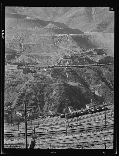 Utah Copper: Bingham Mine. Part of the open-pit workings of the Utah Copper Company, at Bingham Canyon, Utah. The steam locomotive is bringing in empty ore cars from the Utah Copper Company mills at Magna and Arthur