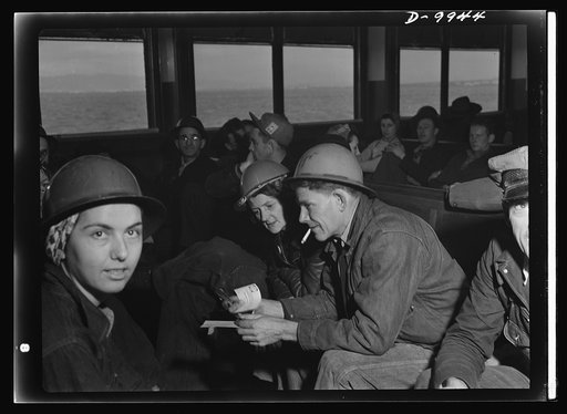 California shipyard workers. En route to the shipyards across the bay, tin-hatted San Francisco war workers have time for relaxation and discussion on the fourty-five minute ferry ride to the Richmond Shipbuilding Company yards