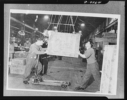 Lend-Lease to Britain. English workmen handle a case of motor equipment arriving from the United States under lend-lease, at an unpacking bay of an ordnance depot in England