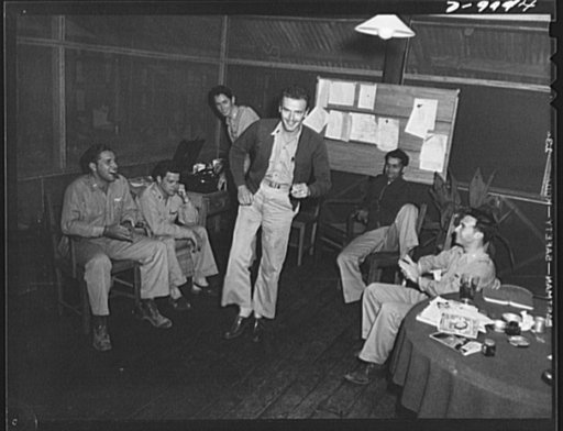 An American flying squadron in India. Jive to "My Mamma Done Tole Me" makes "Happy Tavern" seem like home for a group of American pilots in India. Lieutenant L.D. Putnam of Portland, Oregon starts the session while other pilots applaud his rug-cutting. The pilots are members of an India-China ferry 