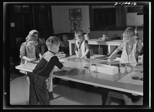 War workers' nursery. Finger painting is a healthy outlet for nursery school youngsters. With oilcloth aprons to protect their clothes, the elbow's the limit for a junior artist