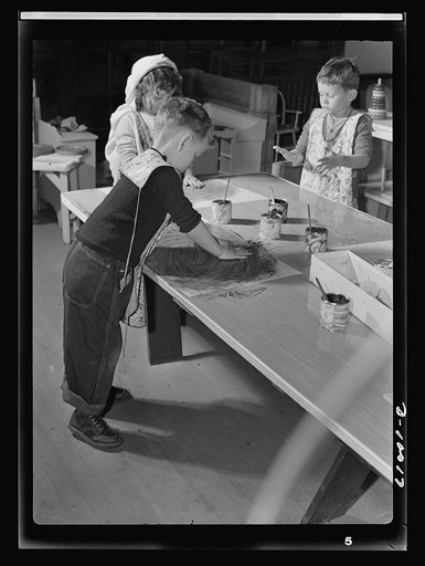 War workers' nursery. Finger painting is a healthy outlet for nursery school youngsters. With oilcloth aprons to protect their clothes, the elbow's the limit for a junior artist