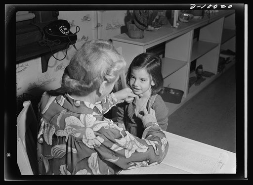 War workers' nursery. Every youngster who attends the Bella Vista Nursery School in Oakland, California must be inspected by Mrs. Elsie Curran, supervisor, before mingling with the other children. Here, five-year-old Ronnie Gold has her chest inspected
