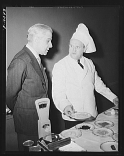 Honorable Cimon P. Diamantopoulos, the ambassador of Greece to the United States, examines food which had first been dehydrated, then rehydrated, for serving at a luncheon in observance of the second anniversary of lend-lease, held March 11, 1943, at Hotel Statler, Washington, D.C.