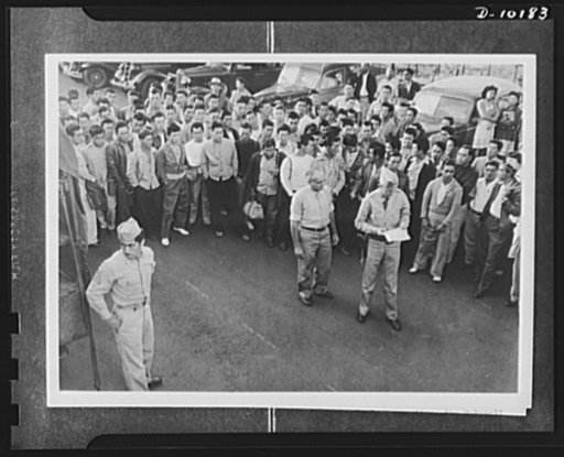 Japanese-American volunteers. Second and larger group on Kauai, Hawaii to go up for physical examination, the Makaweli draft board registrants answer roll call outside their board prior to going up for the physical. Calling roll is Captain J.J. Fallon of the Kuai Service Command. Standing beside the