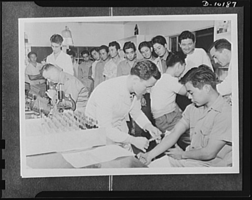Japanese-American volunteers. Impatient to go through the last step in their physical examination--the blood test, these AJA [Americans of Japanese ancestry] volunteers on Kauai press forward to have samples of their blood taken by Sergeant Bernard G. Borden of Hartford, Connecticut (left) and Serge