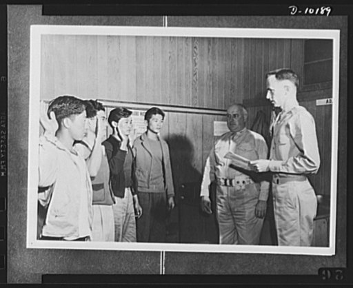 Japanese-American volunteers. Colonel James J. Doyle, second from right, commanding officer of Kauai, Hawaii Service Command looks on as the oath of induction is administered to the four young AJA [Americans of Japanese ancestry] volunteers of Kauai who went through the solemn pledge of allegiance i