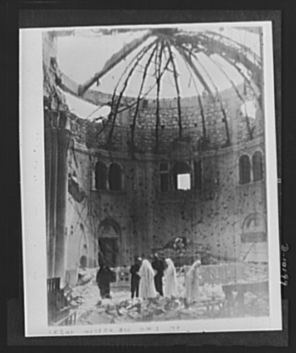 Archbishop Spellman of New York and Brigadier General Auby C. Strickland, U.S. Army 9th Air Forces, view ruins of Chapel of Franciscan Missionaries in Tripoli recently damaged by German night bombers. Monsignor Spellman was guest of General Strickland during his visit to Tripoli