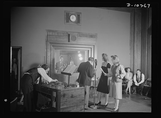 "You Can't Do Business With Hitler." Rehearsing for the radio show "You Can't Do Business With Hitler" are Colonel Charles Ferris, Doris McWhirt, and Virginia Moore at the microphone. In the control room with script and talk-back microphone in hand is Frank Telford, whod directs each production of t