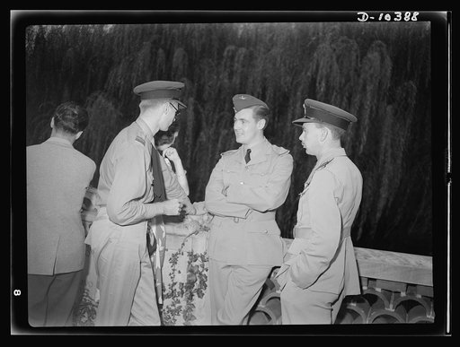 The uniforms are different, but the cause is the same. Officers of the United Nations attend a garden party of the United Nations Club at Dumbarton Oaks, Sunday, September 6, 1942. Left to right: Squadron Leader Lowry, Royal Air Force; Miss Barbara Brady; Pilot Officer James, RAF (Royal Air Force); 