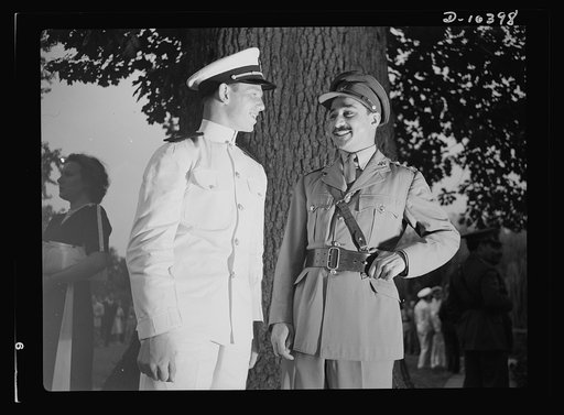 The uniforms are different but the cause is the same. Officers of the United Nations attend a garden party of the United Nations Club at Dumbarton Oaks, Sunday, September 6th, 1942. Left to right: Naval Aviation Cadet John Edward Sinclaire, United States of America and Captain Chaudhuri, Military Ai