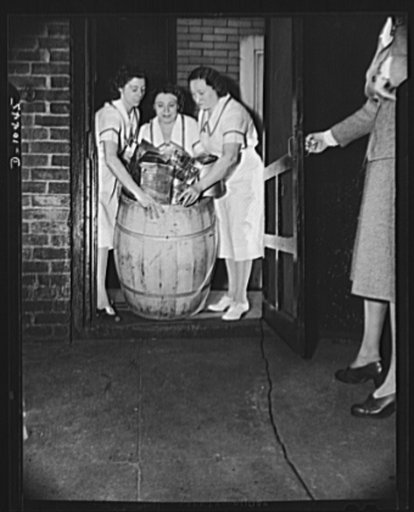 Y.W.C.A. tea room workers, at the 45th and Lexington Avenue home for nurses of the Y.W.C.A., spend an extra hour each day after work to prepare and clean empty tins for city collection in the nation-wide salvage drive. Left to right: Evelyn Dall, Marion Jurison and Jerry Lederoni roll out the filled