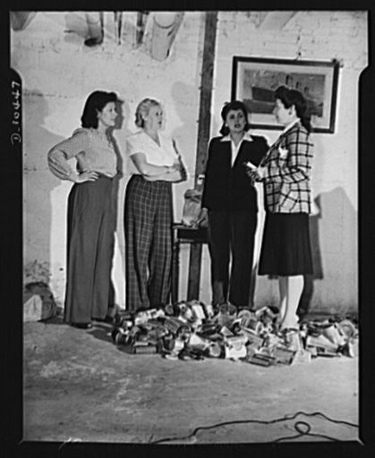 Mrs. Kaplitt, with pad in hand, receives report from houswives, all volunteer workers, who collect, process and deliver empty tin cans for salvage collection. Left to right: Mrs. T. Rubins, Mrs. H. Mars, Mrs. T. Cohen and Mrs. B. Kaplitt