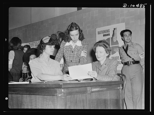 Sugar rationing. Sign here please. Mrs. Bennett Champ Clark, wife of the Senator from Missouri, gets a preview of sugar rationing at Western High School, Washington, D.C. Like millions of other American householders, Mrs. Clark will be among those registering for their sugar rationing cards from May