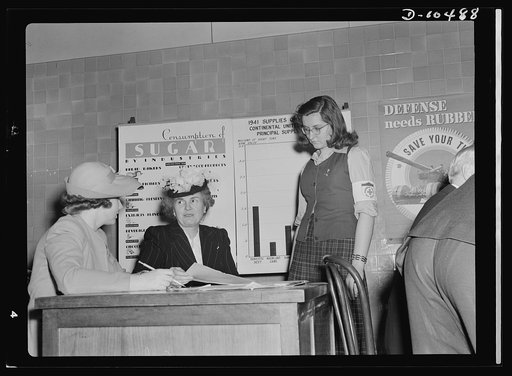 Sugar rationing. Mrs. Henry Wallace, wife of the Vice President, learns how millions of American householders will register for their sugar rationing cards from May 4th through May 7th. She's getting the information from a teacher and pupil at Western High School, Washington, D.C.