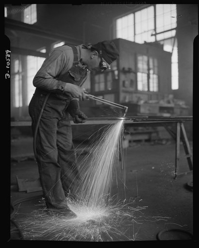 Denver, Colorado. Twenty-four hours a day the sparks from acetylene torches of steel workers in eight Denver fabricating plants are flying thick and fast that the U.S. Navy may carry the battle to the enemy in all parts of the world. Here in secluded Denver, the world's largest city not on a navigab