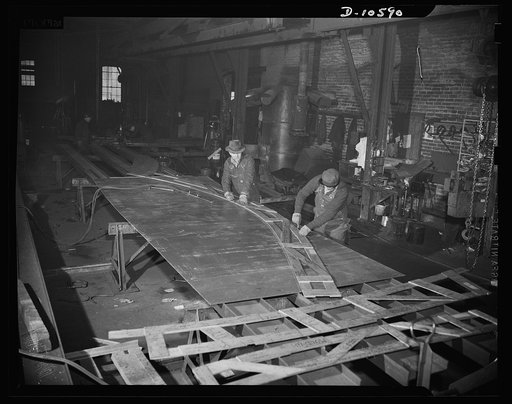 Denver, Colorado. The interior of one of eight Colorado plants engaged in 56 million dollar ship-building program, showing workers who once made highway bridge girders, gold mining machinery and water culverts, laying out parts of an escort vessel. The parts will be assembled at Mare Island Navy Yar