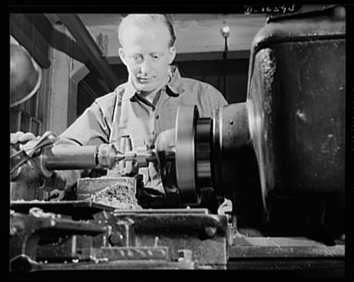 Man working on a lathe which is shaping precision instruments