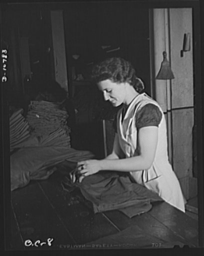 Best Coat and Apron Manufacturing Company. Examiner clipping threads from finished uniforms