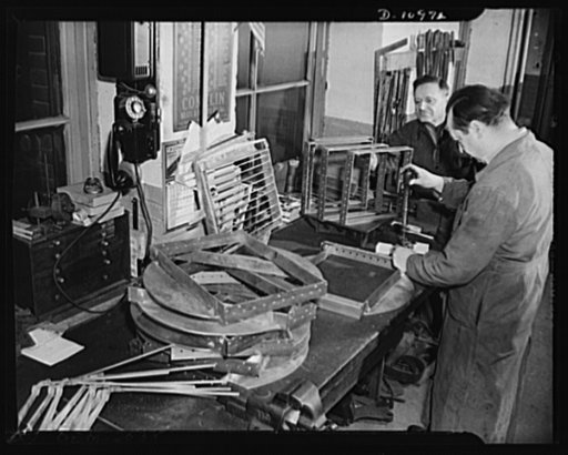 Conversion (auto accessory plant). Photo shows Benjamin Lapides (right) and his father Leon Lapides, owners of the firm at work assembling signalling devices for the U.S Navy searchlights. Firm converted from manufacture of automotive accessories to ninety percent war production