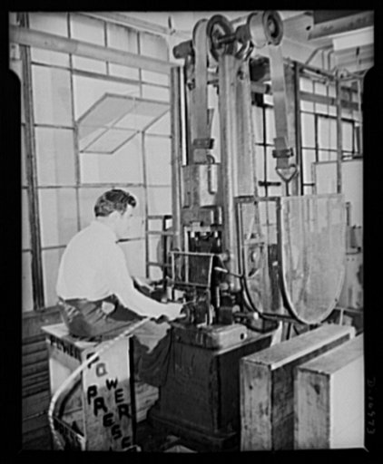 Conversion. Compacts to ordnance. Rex Manufacturing Company, New Rochelle, New York. Stamping the seal of the United States on shells for brass buttons