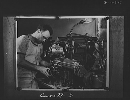 Conversion. From garage to defense workshop. An example of Carell's ingenuity is this small milling machine which he rigged up with a grinder to form a surface-grinding machine. He also installed a cooling system. Operator is Walter Drzewiecki