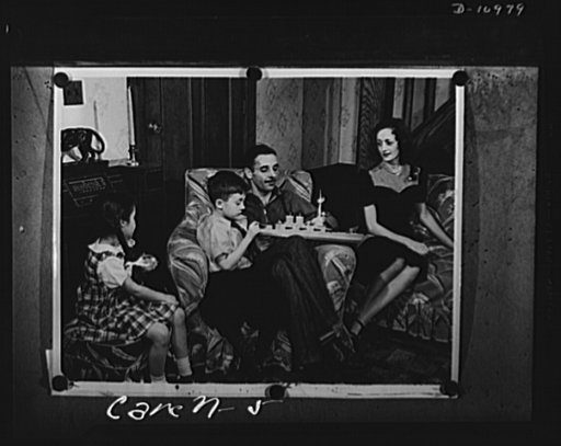 Conversion. From garage to defense workshop. In the living room of his home in suburban Passaic, New Jersey, Carell shows his son, George junior, a toy battleship as his wife and daughter look on. When mechanical work was just his hobby, he made his children a fine model railroad