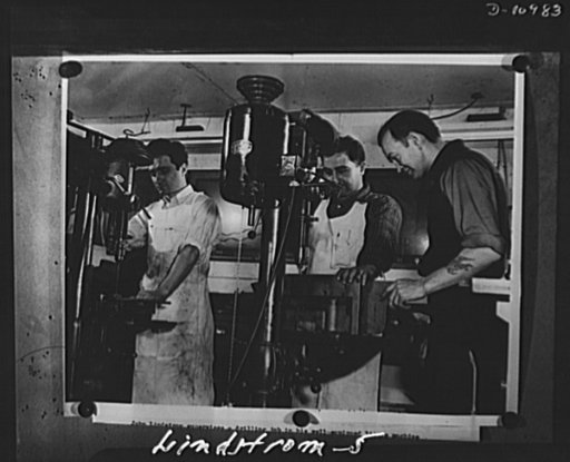 Conversion. From garage to defense workshop.  Here he is shown supervising a drilling job. The drill jigs in which the parts are held were made and designed by Lindstrom
