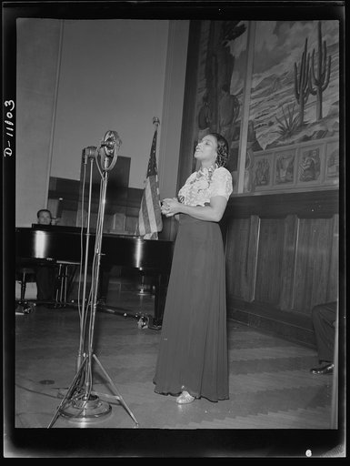 Washington, D.C. Marian Anderson broadcasting a Negro spiritual at the dedication of a mural installed in the United States Department of the Interior building, commemorating the outdoor concert which she gave at the Lincoln Memorial after the Daughters of Revolution refused to allow her to sing in 