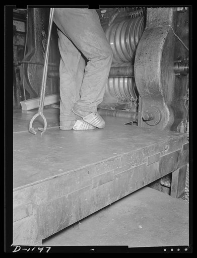 Aluminum. Reynolds Metal Company, Louisville, Kentucky. Safely factors are not forgotten in rush orders for war production. This worker who handles hot ingots in the rolling mill, wears these size fifteen aluminum toe guards to protect his feet