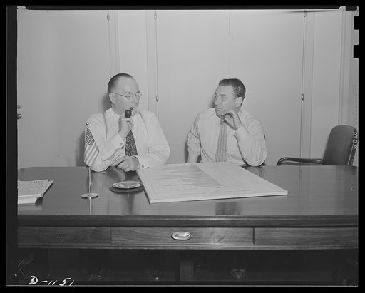 Donald M. Nelson (left), Chairman, War Production Board (WPB), and Leon Henderson, Administrator, Office of Price Administration (OPA) and Director, Civilian Supply Division of the Office of Production Management (OPM), member of the Supply Priorities and Allocations Board; conferring in Washington,