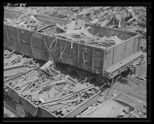 Steel manufacture, Allegheny-Ludlum. Into the charging boxes goes this carload of scrap metal. Steel mills operating at capacity cannot afford to run short of these precious bits of cast away metal. The charging boxes foreground, will carry the scrap to the furnace for remelting