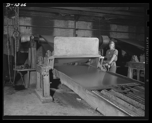 Steel manufacture, Allegheny-Ludlum. Shine your sheets, mister! This machine is used to polish the surface of stainless, to make it smooth and bright and clean. This is just one of the many units of special equipment required for the production of high quality steel for our defense needs