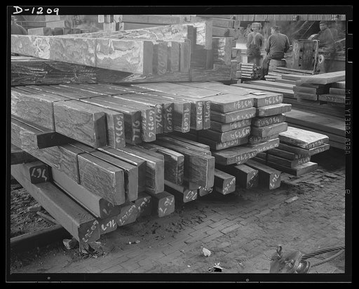 Steel manufacture, Allegheny-Ludlum. No lumberyard this! These are billets of stainless steel, ready to through the hot rolling mills to be pressed into strips. The chipping and grinding on the surfaces of these billets is designed to remove all contamination and defects, so that the steel may meet 